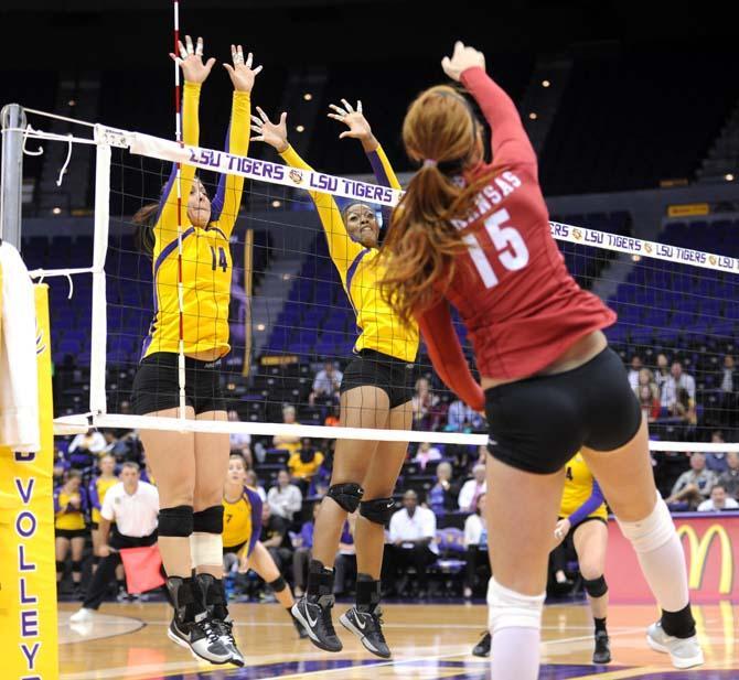 LSU sophomore setter Malorie Pardo (14) and freshman middle bloacker Briana Holman (13) attempt to block Arkansas freshman outside hitter Savannah Voelzke on Sunday, October 27, 2013 in the SEC match-up at the PMAC.