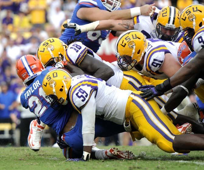 Multiple members of the LSU defensive line attempt to bring down Florida freshman running back Kelvin Taylor (21) Saturday, Oct. 12, 2013 during the Tigers' 17-6 victory against the Gators in Tiger Stadium.