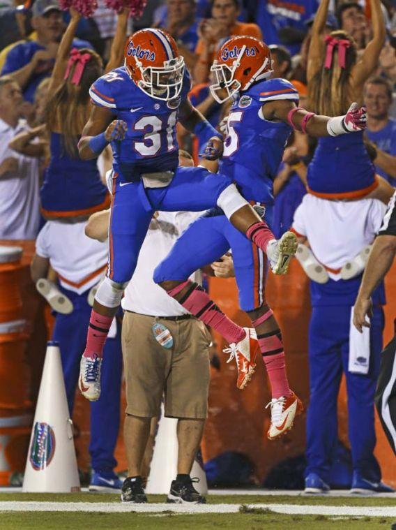 Florida defensive back Loucheiz Purifoy, right, celebrates his 42-yard touchdown interception against Arkansas with defensive back Cody Riggs (31) during the first half of an NCAA college football game in Gainesville, Fla., Saturday, Oct. 5, 2013.(AP Photo/John Raoux)