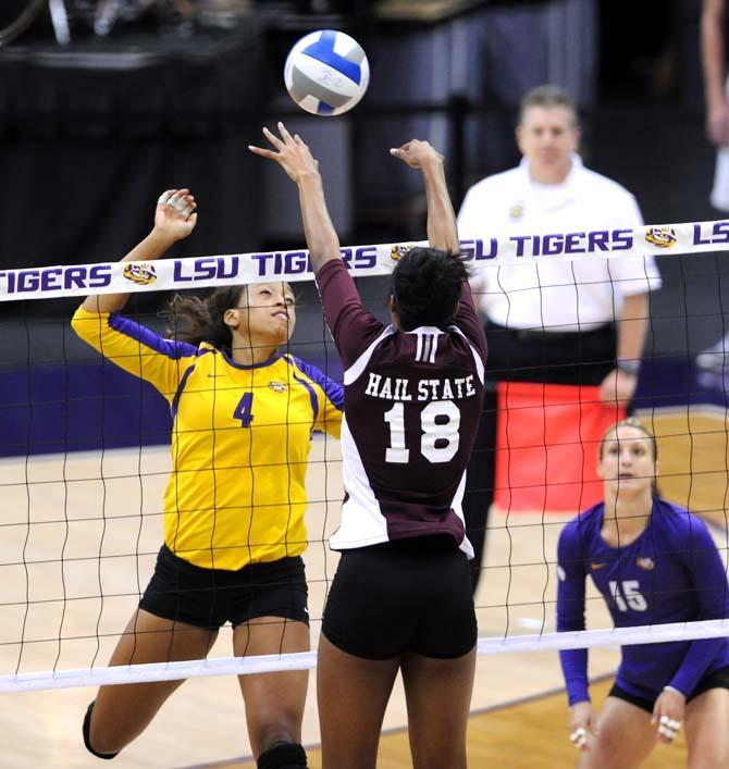 LSU senior middle blocker Desiree Elliott (4) attempts to block a shot from Mississippi State sophomore middle blocker Alex Warren (18) Sunday, Oct. 13, 2013 during the Tigers' victory against the Bulldogs in the PMAC.