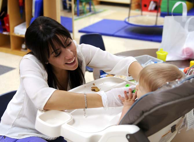 Speech Pathology graduate student Brenna Gonzales encourages Grant Worthington to move his tongue forward Monday, October 7, 2013 in Hatcher Hall.