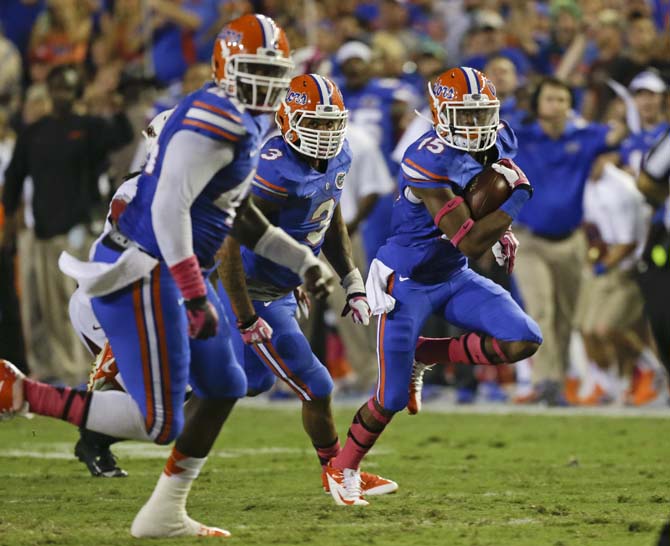 Florida defensive back Loucheiz Purifoy (15) runs for a 42-yard touchdown after intercepting an Arkansas pass during the first half of an NCAA college football game in Gainesville, Fla., Saturday, Oct. 5, 2013.(AP Photo/John Raoux)