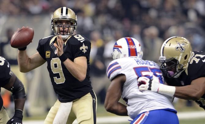 New Orleans Saints quarterback Drew Brees (9) passes under pressure from Buffalo Bills' Jerry Hughes (55) during the first half of an NFL football game in New Orleans, Sunday, Oct. 27, 2013. (AP Photo/Bill Feig)