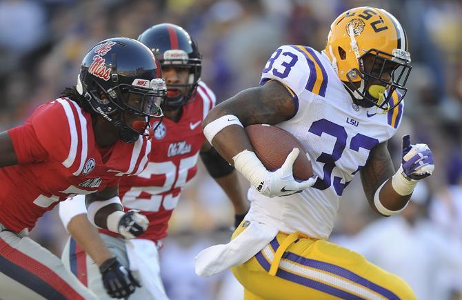 LSU freshman running back Jeremy Hill (33) progresses past Ole Miss freshman and sophomore defensive backs Trae Elston (7) and Cody Prewitt (25) to score the first LSU touchdown of the LSU vs. Ole Miss game on Saturday, November 17, 2012 in Tiger Stadium.