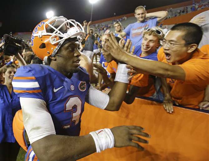 Florida quarterback Tyler Murphy (3) high-fives fans after Florida defeated Arkansas 30-10 in an NCAA college football game in Gainesville, Fla., Saturday, Oct. 5, 2013. (AP Photo/John Raoux)