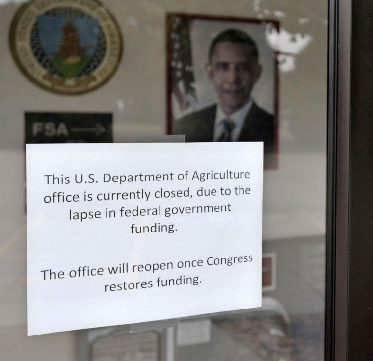 A sign on the door to the USDA Service Center explains that they are closed due to the government shutdown and will not reopen until Congress restores funding, Tuesday, Oct. 1, 2013 in Champaign, Ill. (AP Photo/News-Gazette/John Dixon) MANDATORY CREDIT