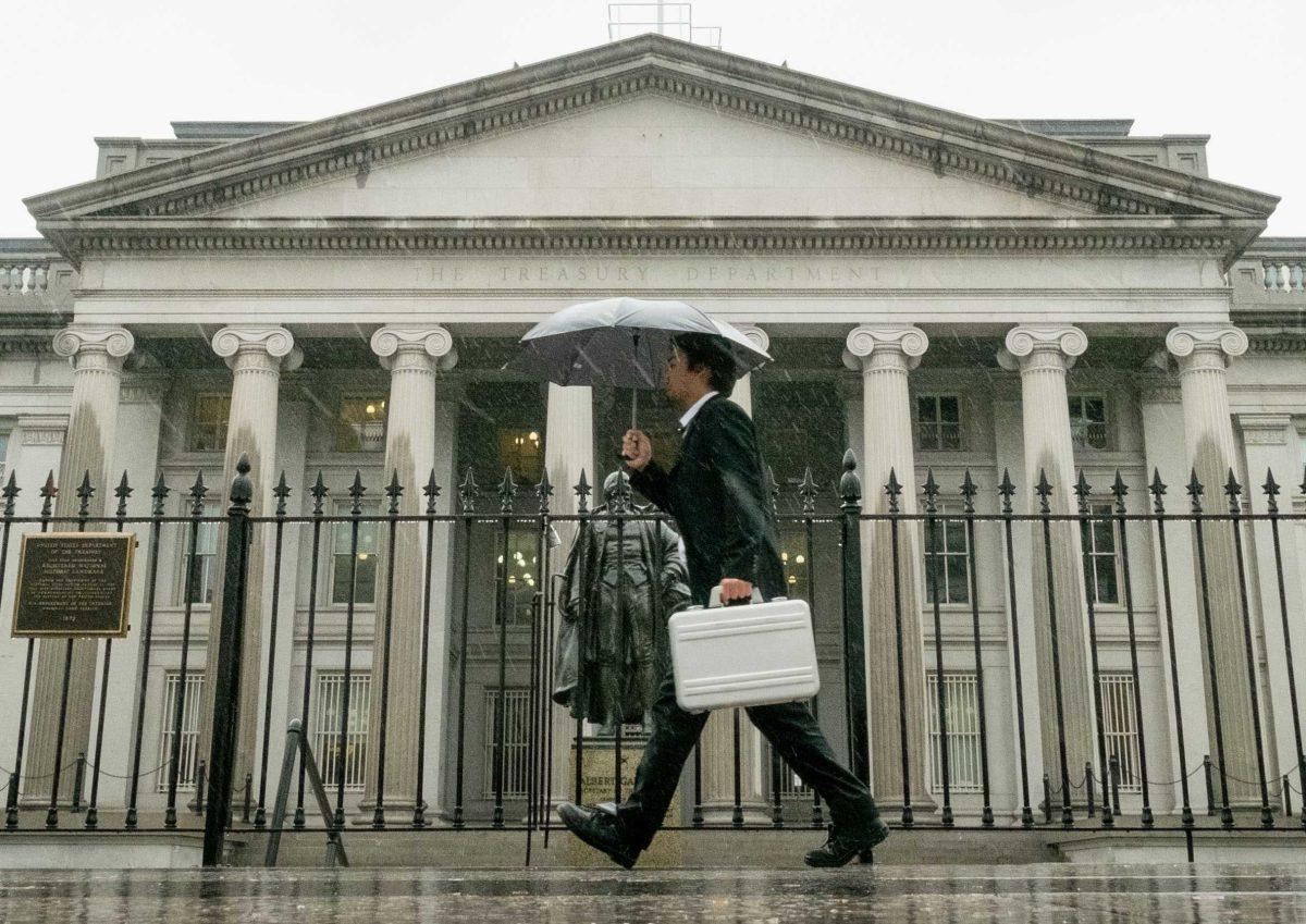 In this Thursday, Oct. 10, 2013 photo, a pedestrian walks past the U.S. Treasury Building in Washington on a rainy day. The national debt actually reached the limit in May 2013. Since then, Treasury Secretary Jacob Lew has made accounting moves to continue financing the government without further borrowing. But Lew says those measures will be exhausted by Thursday, Oct. 17, 2013. The government will then have to pay its bills from its cash on hand &#8212; an estimated $30 billion &#8212; and tax revenue. (AP Photo/J. David Ake)