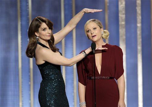 FILE - In this Sunday, Jan. 13, 2013, file photo, provided by NBC, co-hosts Tina Fey, left, and Amy Poehler appear on stage during the annual Golden Globe Awards, at the Beverly Hilton Hotel, in Beverly Hills, Calif. The Hollywood Foreign Press Association said Tuesday, Oct. 15, 2013, that Fey and Poehler have signed up to host the Golden Globes for two more years. (AP Photo/NBC, Paul Drinkwater, File)