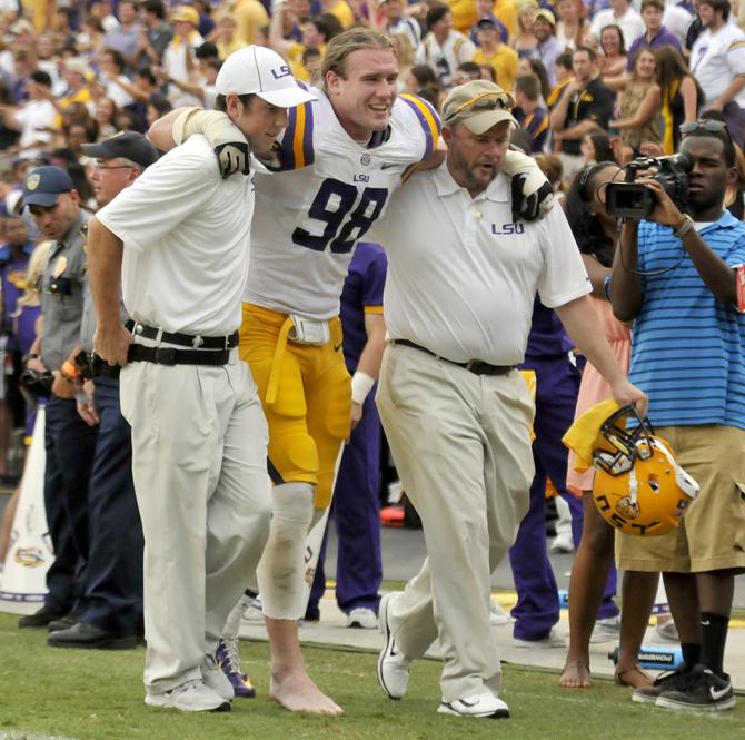 LSU junior defensive end Jordan Allen (98) is helped into the locker room Saturday, Oct. 12, 2013 during the 17-6 victory against Florida in Tiger Stadium.