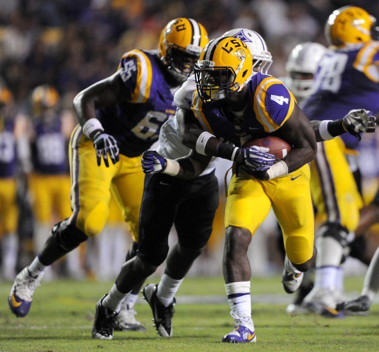 LSU senior running back Alfred Blue (4) gets tackled by a Furman defender Saturday night, Oct. 26, 2013 during the Tigers' 48-16 win against Furman in Tiger Stadium.