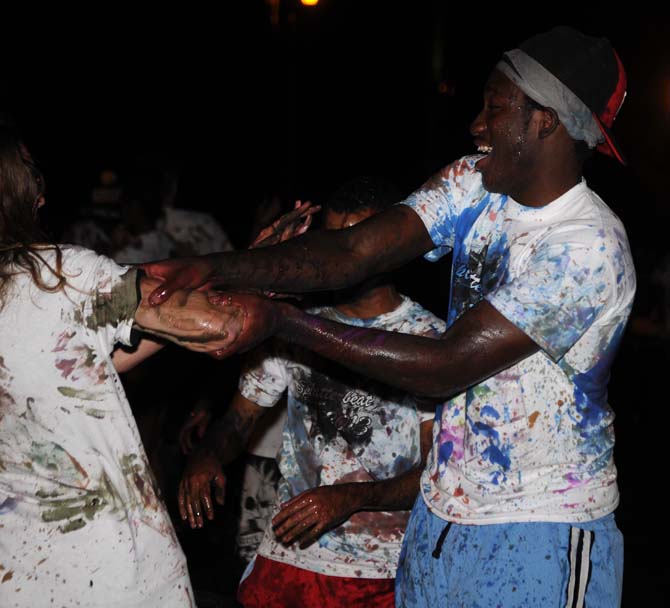 An LSU student rubs paint on a fellow student's arm on Monday, October 21, 2013, during the Splatterbeat homecoming week event on the Parade Ground.