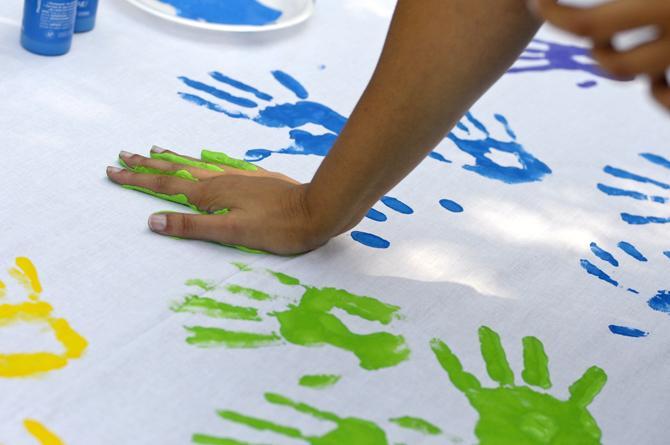 A student places her painted hand down to leave a handprint at Spectrum's table Wednesday, Oct. 10, 2012, in Free Speech Alley. Spectrum, a student organization for LGBTQ students and their allies, is celebrating National Coming Out Day.