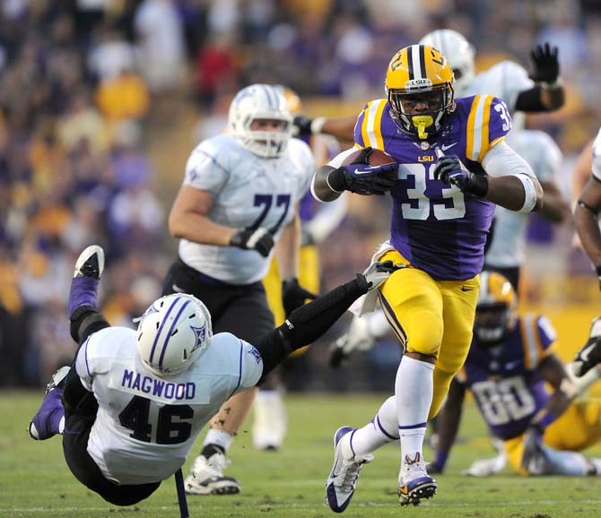 LSU sophomore running back Jeremy Hill (33) eludes Furman sophomore linebacker Cory Magwood (46) on Saturday, Oct. 26, 2013 during the Tigers' 48-16 win against Furman in Tiger Stadium.