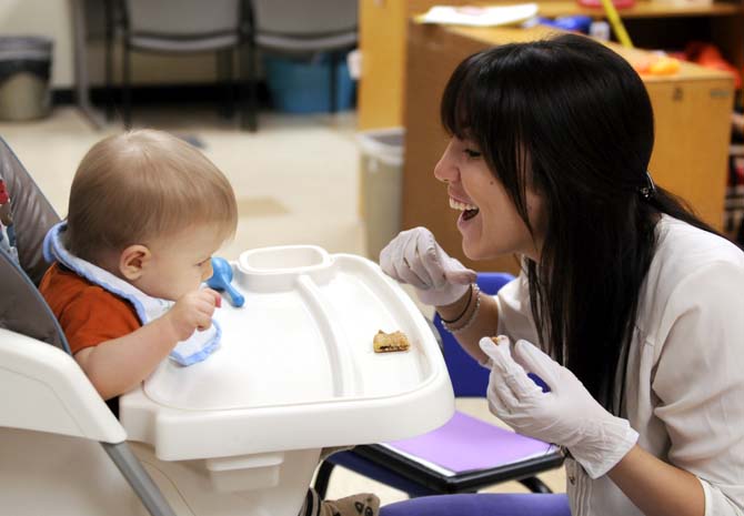 Speech Pathology graduate student Brenna Gonzales encourages Grant Worthington to move his tongue forward Monday, October 7, 2013 in Hatcher Hall.