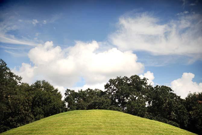 One of LSU's famous Indian Mounds is bathed in sunlight Wednesday, Oct. 2, 2013 while clouds float overhead.