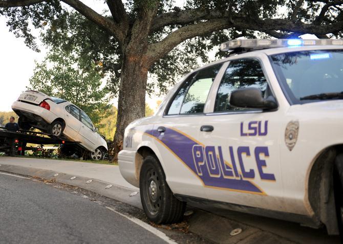 A Nissian Sentra is towed Tuesday, Aug. 27, 2013 after it flipped into University Lake near the Kappa Alpha Theta sorority house.