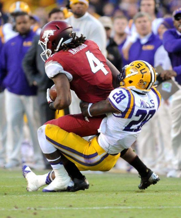 LSU sophomore cornerback Jalen Mills (28) attempts to bring down Arkansas sophomore wide receiver Keon Hatcher (4) Friday, Nov. 29, 2013 during the Tigers' 31-27 victory against the Razorbacks in Tiger Stadium.