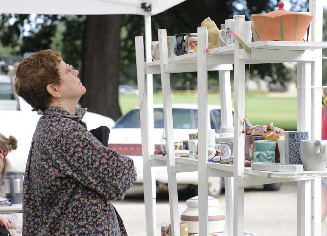 A woman gazes upon the available ceramic art pieces for sale on Tuesday, November 19, 2013, during the LSU Art and Design ceramic sale in Free Speech Alley.