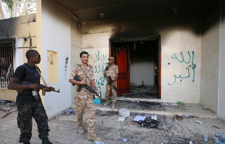 Libyan military guards check one of the U.S. Consulate's burnt out buildings during a visit by Libyan President Mohammed el-Megarif, not shown, to the U.S. Consulate to express sympathy for the death of the American ambassador, Chris Stevens and his colleagues in the deadly attack on the Consulate last Tuesday, September 11, in Benghazi, Libya, Friday, Sept. 14, 2012. The American ambassador to Libya and three other Americans were killed when a mob of protesters and gunmen overwhelmed the U.S. Consulate in Benghazi, setting fire to it. Ambassador Chris Stevens, 52, died as he and a group of embassy employees went to the consulate to try to evacuate staff as a crowd of hundreds attacked the consulate Tuesday evening, many of them firing machine-guns and rocket-propelled grenades. The Arabic on the building reads, "God is Great, and there is no God but Allah and Mohammed is his messenger." (AP Photo/Mohammad Hannon)