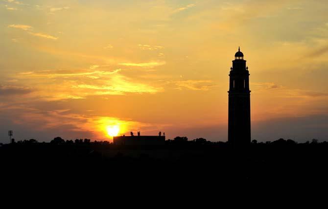 Memorial Tower is silhouetted against the skyline as the sun sets Monday behind Tiger Stadium.