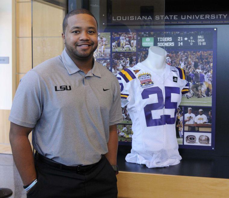 Former LSU running back Jusin Vincent stands next to his old jersey Monday, Nov. 19, 2013 in the Football Operations Building.