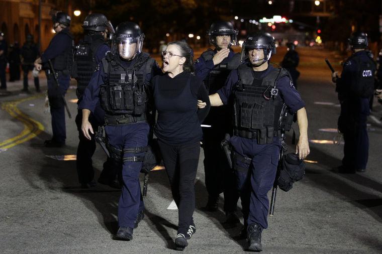 A protester chants her slogans as she is taken into custody after participating in a protest outside the new Chinatown Walmart store on Thursday, Nov. 7, 2013, in Los Angeles. Los Angeles police have arrested more than 50 people in the protest of more than 200 people. (AP Photo/Jae C. Hong)