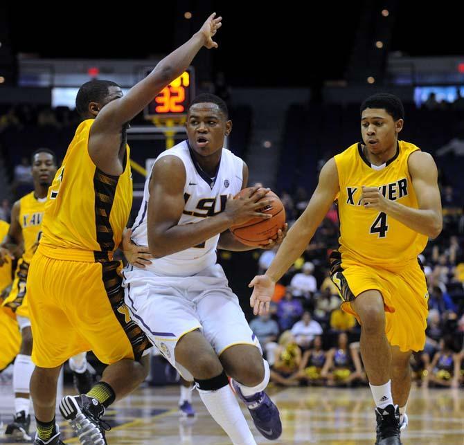 LSU freshman forward Jarell Martin (12) maneuvers past Xavier players Wednesday, Nov. 6, 2013, during the Tigers' 80-45 victory at the Pete Maravich Assembly Center