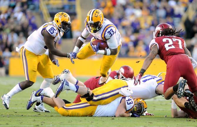 LSU sophomore running back Jeremy Hill (33) leaps over a pile of players Friday, Nov. 29, 2013 during the Tigers' 31-27 victory against Arkansas in Tiger Stadium.