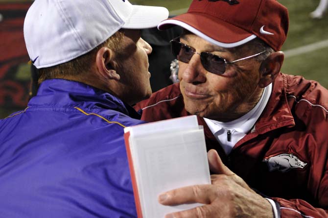 LSU head coach Les Miles (left) hugs Arkansas head coach John L. Smith (right) after the Tiger's 20-13 win over the Razorbacks on November 23, 2012 in Fayetteville.