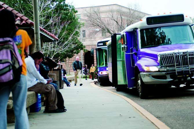 Students patiently wait for their bus to arrive at the bus stop near Hodges Hall.