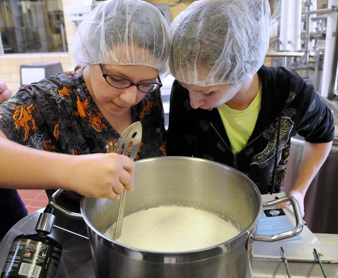 LSU animal science senior Katie Coleman (left) and animal science senior Mandy Montreuil (right) examine the process of making cottage cheese Thursday, Oct. 31, 2013, at the Dairy Science Building.