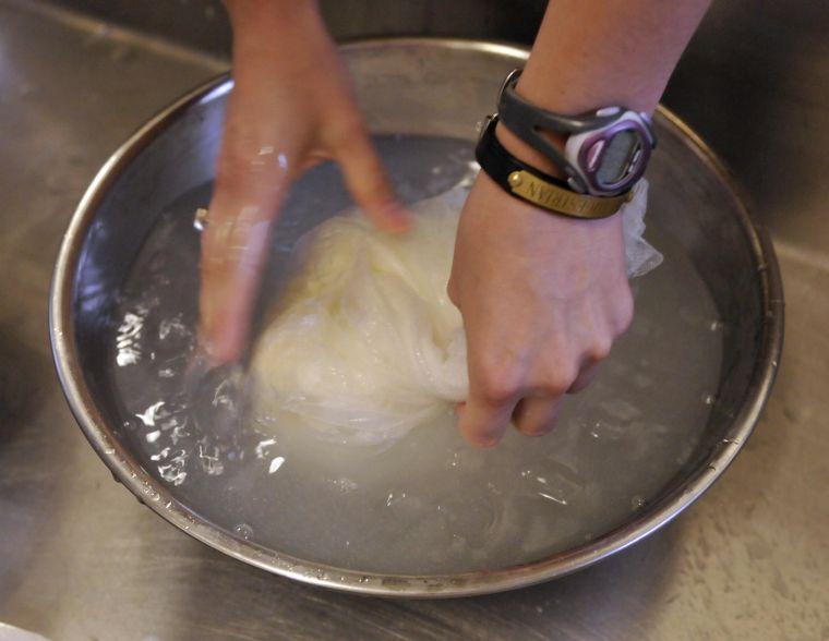 Animal science senior Corinne Plough rinses the cottage cheese in cold water Wednesday, Oct. 31, 2013 in the Dairy Products class in the Dairy Science Building.