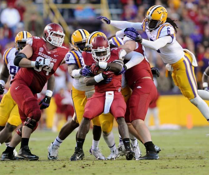 Members of the LSU defense attempt to bring down Arkansas freshman running back Alex Collins (3) Friday, Nov. 29, 2013 during the Tigers' 31-27 victory against the Razorbacks in Tiger Stadium.