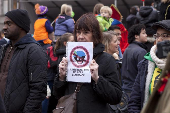 A protester holds a sign Sunday, Nov. 17, 2013, in protest of Zwarte Pieten in the Sinterklaas tradition in Dam Square, Amsterdam.