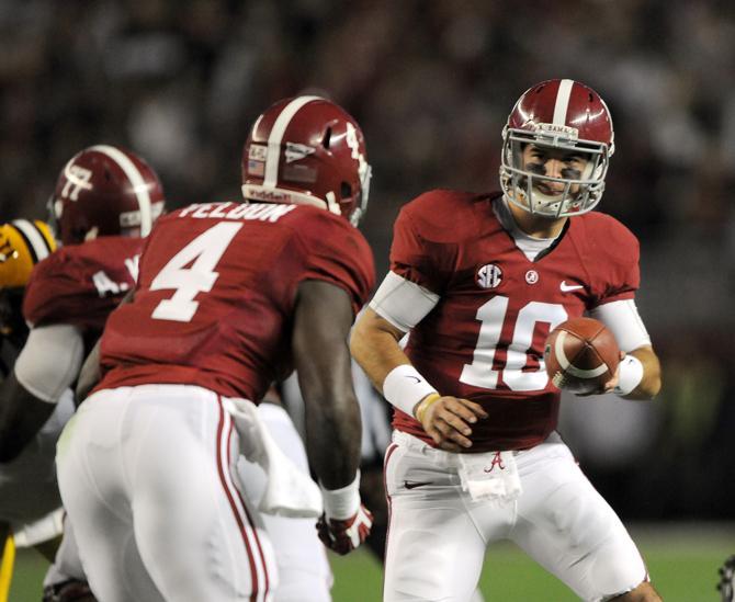 Alabama senior quarterback AJ McCarron (10) hands off to sophomore running back T.J. Yeldon on Saturday, Nov. 9, 2013 before the Crimson Tide's 38-17 victory against the LSU Tigers at Bryant-Denny Stadium in Tuscaloosa, AL.
