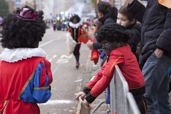 A child dressed as Zwarte Piet watches the Sinterklaas parade Sunday, Nov. 17, 2013, in Amsterdam