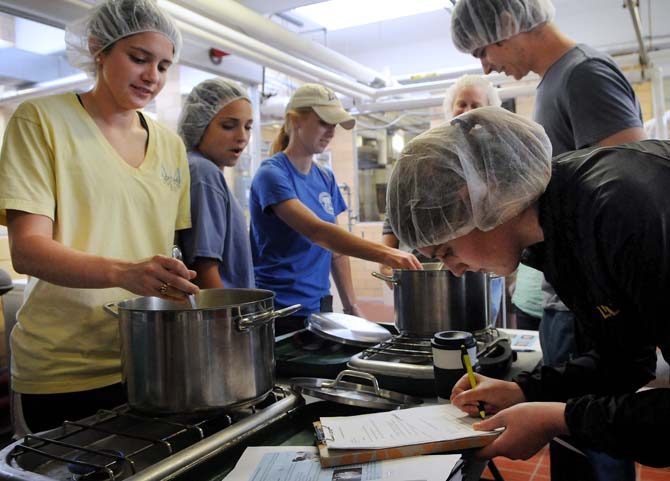 LSU animal science senior Corinne Plough (left) stirs the cottage cheese while animal science junior Alex Brown (right) records the process Thursday, Oct. 31, 2013, in the Dairy Science Building.