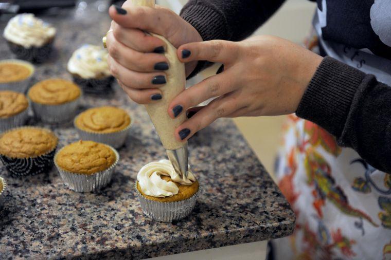 LSU Spanish junior Elise Abshire, owner of Fleur D'Elise Treats, puts cream cheese icing atop her pumpkin muffins Monday, Nov. 11, 2013 in her home in Baton Rouge.