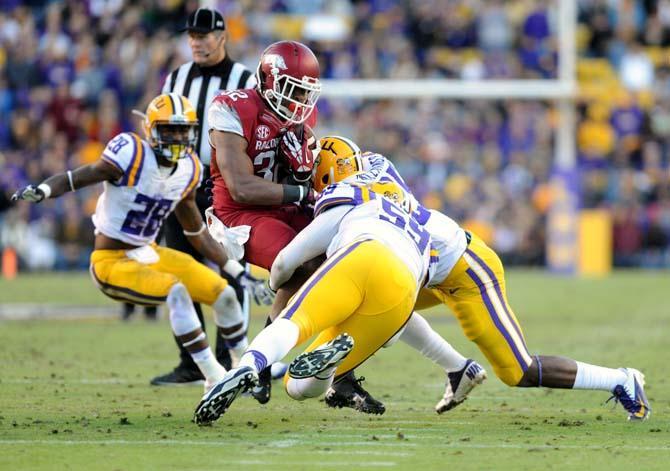 Members of the LSU defense attempt to bring down Arkansas sophomore running back Jonathan Williams (32) Friday, Nov. 29, 2013 during the Tigers' 31-27 victory against the Razorbacks in Tiger Stadium.