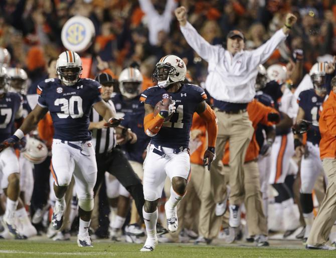 FILE - In this Nov. 30, 2013 file photo, Auburn cornerback Chris Davis (11) returns a field goal attempt 109-yards to score the winning touchdown over Alabama during the second half of an NCAA college football game in Auburn, Ala. Davis's 109-yard return of a missed field goal to beat Alabama was one of the Iron Bowl's and the season's most memorable plays. (AP Photo/Dave Martin, File)