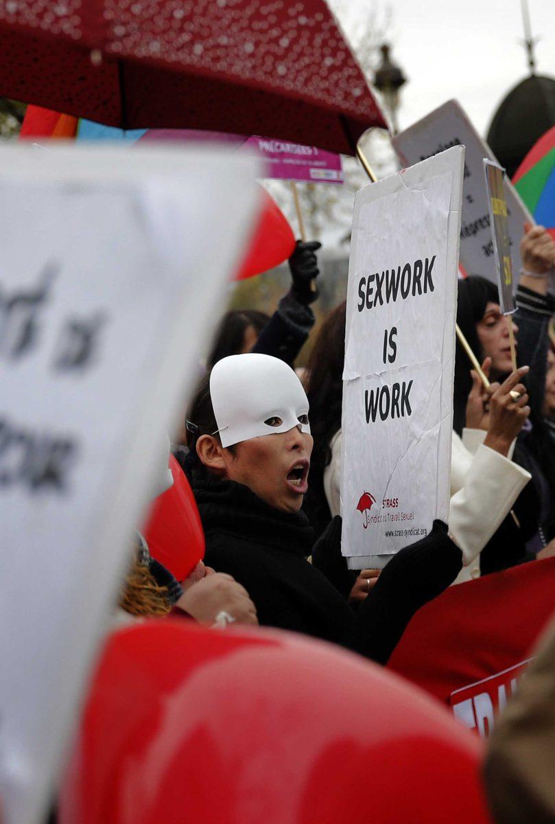 A French sex worker demonstrates outside the National Assembly in Paris, Friday, Nov. 29, 2013. Protestors gather against a government plan to penalize clients caught in the act of soliciting a prostitute. (AP Photo/Christophe Ena)