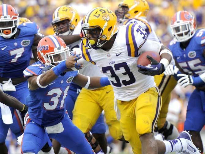 LSU sophomore running back Jeremy Hill (33) fends off Florida junior defensive back Cody Riggs (31) Saturday, Oct. 12, 2013 during the Tigers' 17-6 victory against the Gators in Tiger Stadium.