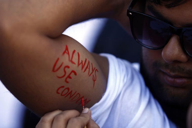 A Nepalese man paints on his arms "Always use condom" message at an event to mark World AIDS Day in Katmandu, Nepal, Sunday, Dec. 1,2013. World AIDS Day is celebrated on Dec. 1 every year to raise awareness about HIV/AIDS.(AP Photo/Niranajan Shrestha)