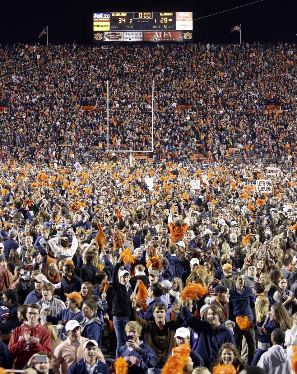 Auburn fans storm the field after their 34-28 after a win over top-ranked Alabama in an NCAA college football game in Auburn, Ala., Saturday, Nov. 30, 2013. (AP Photo/Dave Martin)