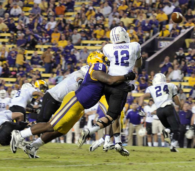 LSU junior defensive tackle Ego Ferguson (9) tackles Furman sophomore quarter back Reese Hannon (12) Saturday, Oct. 26, 2013, during the Tigers' 48-16 win against Furman in Tiger Stadium.