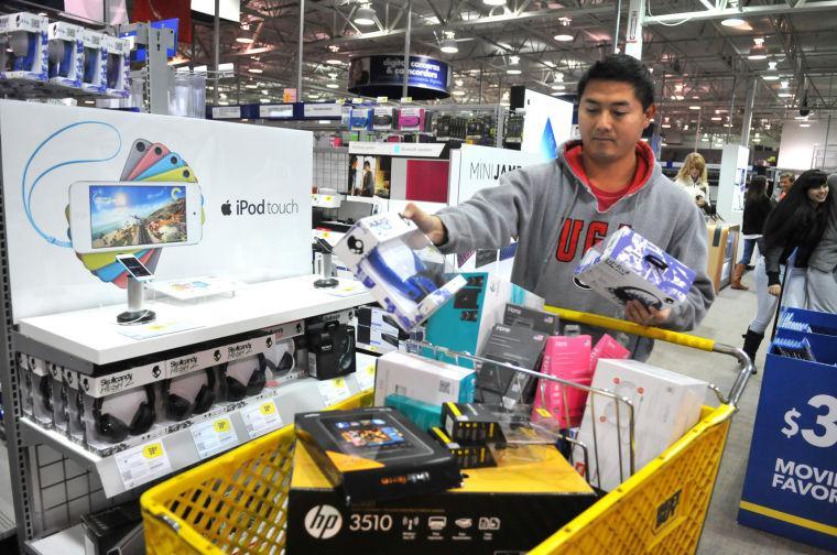 Steven Doan picks up a few gifts at Best Buy in Savannah, Ga., during a very quiet Black Friday morning. Doan, who often does most of his shopping online, decided to go out early Friday Nov. 29, 2013, in hopes that he would avoid the big crowds that shopped when the stores opened Thanksgiving Day. (AP Photo/Savannah Morning News, Richard Burkhart)