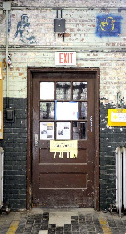 Signs are displayed on a door Tuesday afternoon inside the Studio Arts Buildings on campus.