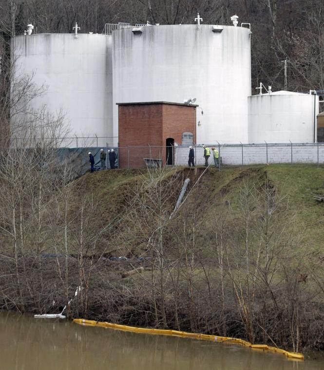 FILE - In this Monday, Jan. 13, 2014, file photo, workers inspect an area outside a retaining wall around storage tanks where a chemical leaked into the Elk River at Freedom Industries storage facility in Charleston, W.Va. Department of Environmental Protection spokesman Tom Aluise says inspectors found five violations Monday at a Nitro, W.Va., site where Freedom Industries moved its coal-cleaning chemicals after last Thursday's spill. Inspectors found that, like the Charleston facility where the leak originated, the Nitro site lacked appropriate secondary containment. In Charleston, a porous containment wall allowed the chemical to ooze into the Elk River. (AP Photo/Steve Helber, File)