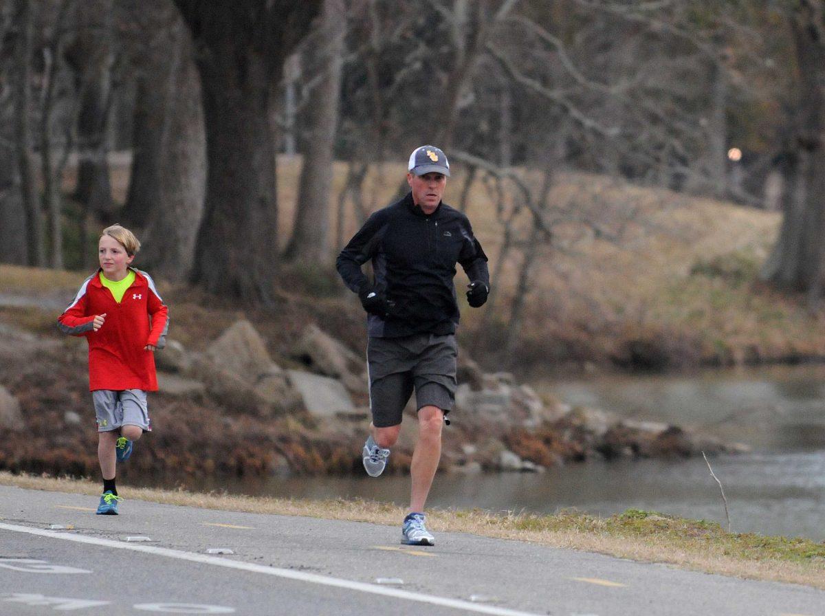 A jogger runs around the University Lake on Thursday, Jan. 23, 2014.