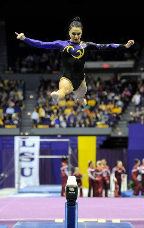 LSU junior all-around gymnast Rheagan Courville leaps during her routine on the beam Friday, Jan. 31, 2014 during the Tigers' 197.650-196.825 victory against Alabama in the PMAC.